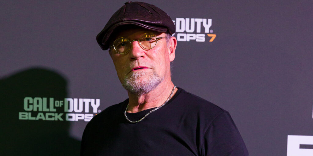 Michael Rooker poses in front of a branded backdrop during the press junket for Call of Duty: Black Ops 7.