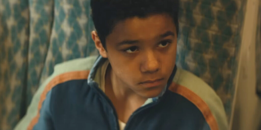 A young Samson looks up while sitting on the train in 28 Years Later: The Bone Temple.