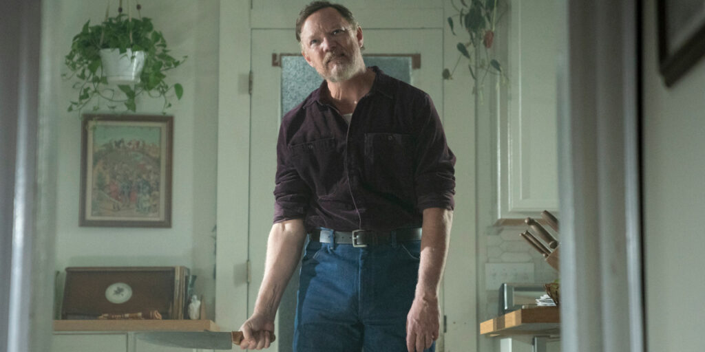 A maniacal Matthew Lillard stands holding a knife in Five Nights At Freddy's 2.