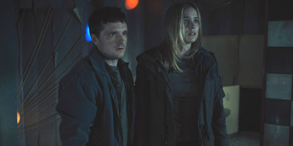 A concerned Josh Hutcherson and Elizabeth Lail stand in a dark Freddy Fazbear restaurant in Five Nights at Freddy's 2.