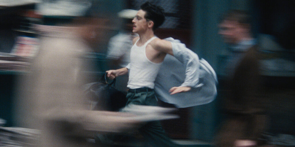 Timothee Chalamet runs frantically through a crowd in Marty Supreme.