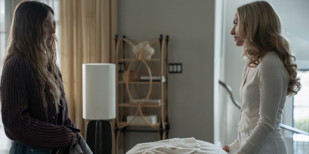 Sydney Sweeney and Amanda Seyfried stare each other down across a living room in The Housemaid.