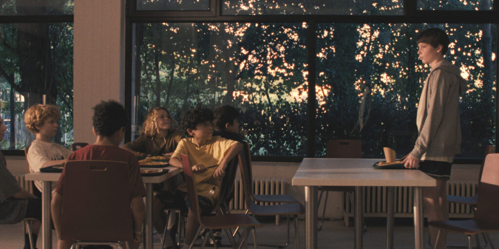 Everett Blunck stands separated from the rest of his peers in the cafeteria in The Plague.