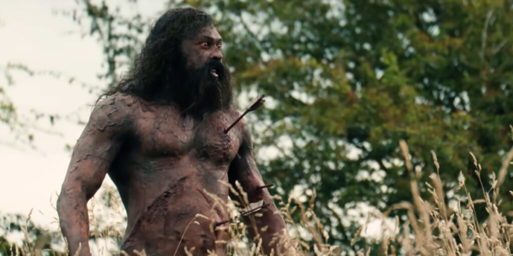 Chi Lewis-Parry stands angrily in a field with arrows in his chest in 28 Years Later: The Bone Temple.