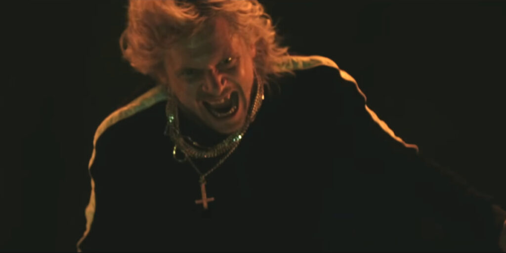 A wind swept Jack O'Connell stands grinning maniacally in 28 Years Later: The Bone Temple.