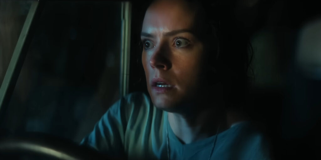 A frightened Daisy Ridley sits behind the wheel of a truck at night in We Bury The Dead.
