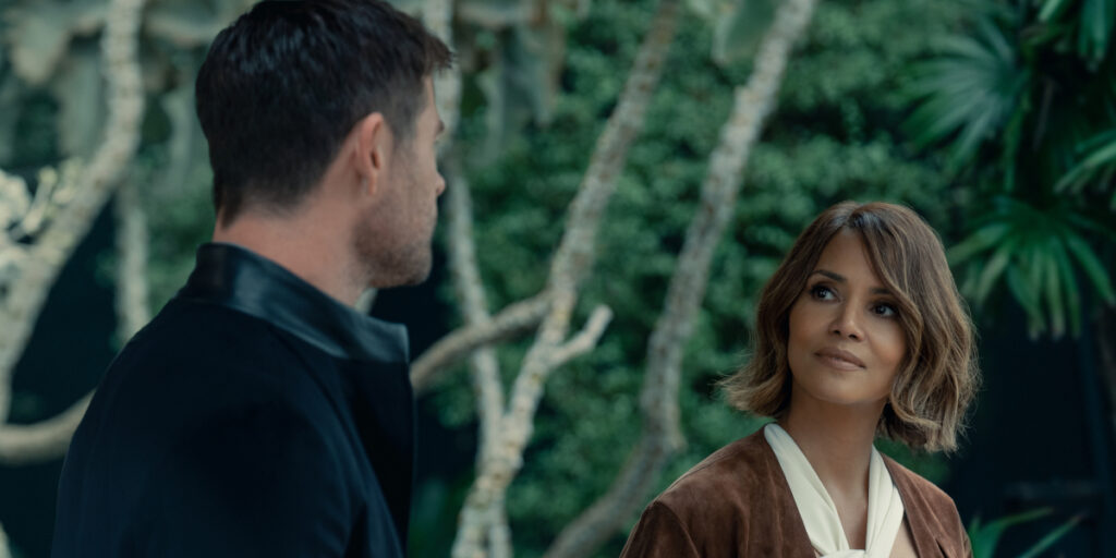 Halle Berry smiles in conversation with Chris Hemsworth in Crime 101.