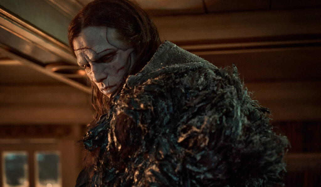 A mournful Jacob Elordi looks over his shoulder in full makeup and costume in Frankenstein.