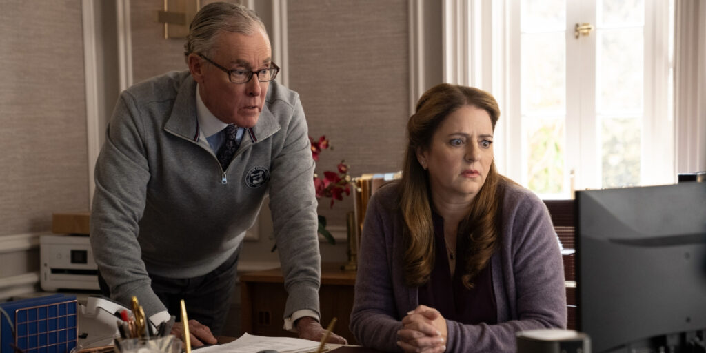 John C McGinley and Annie Mumolo watch a computer monitor with shocked expressions in Rooster.