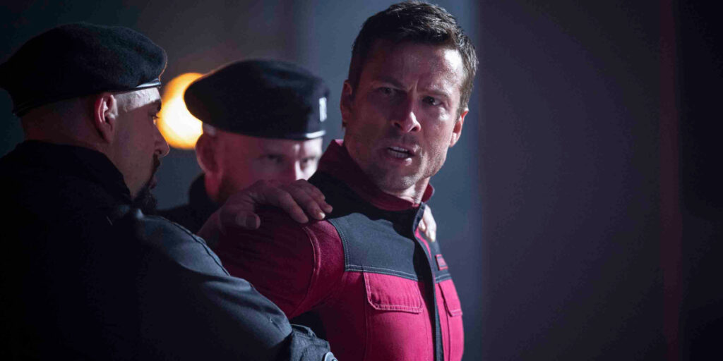 A restrained Glen Powell looks off to the side with a face of anger in The Running Man.