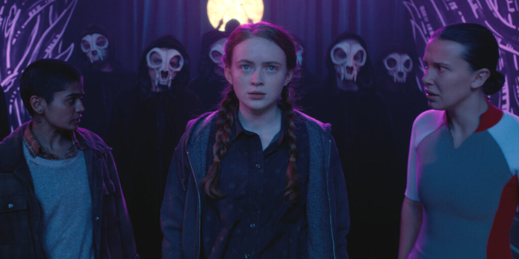 A determined Sadie Sink looks ahead, while Linnea Berthelsen and Millie Bobby Brown watch on in Stranger Things: Season 5.