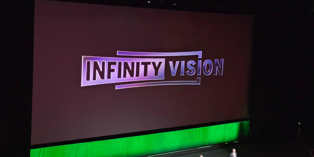 A slide featuring Infinity Vision's logo at Disney's CinemaCon 2026 panel.
