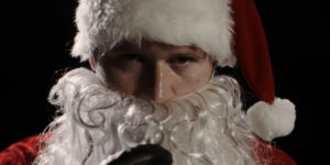 Rohan Campbell stares menacingly as he puts on his Santa beard in Silent Night Deadly Night.