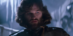 Kurt Russell looks down with concern in a frozen room in The Thing.
