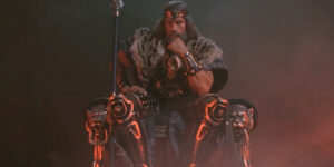 Arnold Schwarzenegger sits on a throne slumped in thought in Conan The Barbarian.